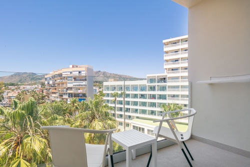 a balcony with two chairs and a table overlooking a city