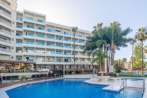 a large swimming pool surrounded by palm trees and buildings