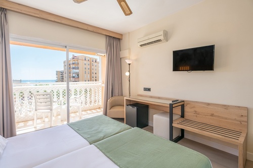 a hotel room with a balcony and a flat screen tv
