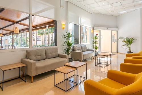 a living room with a couch and yellow chairs