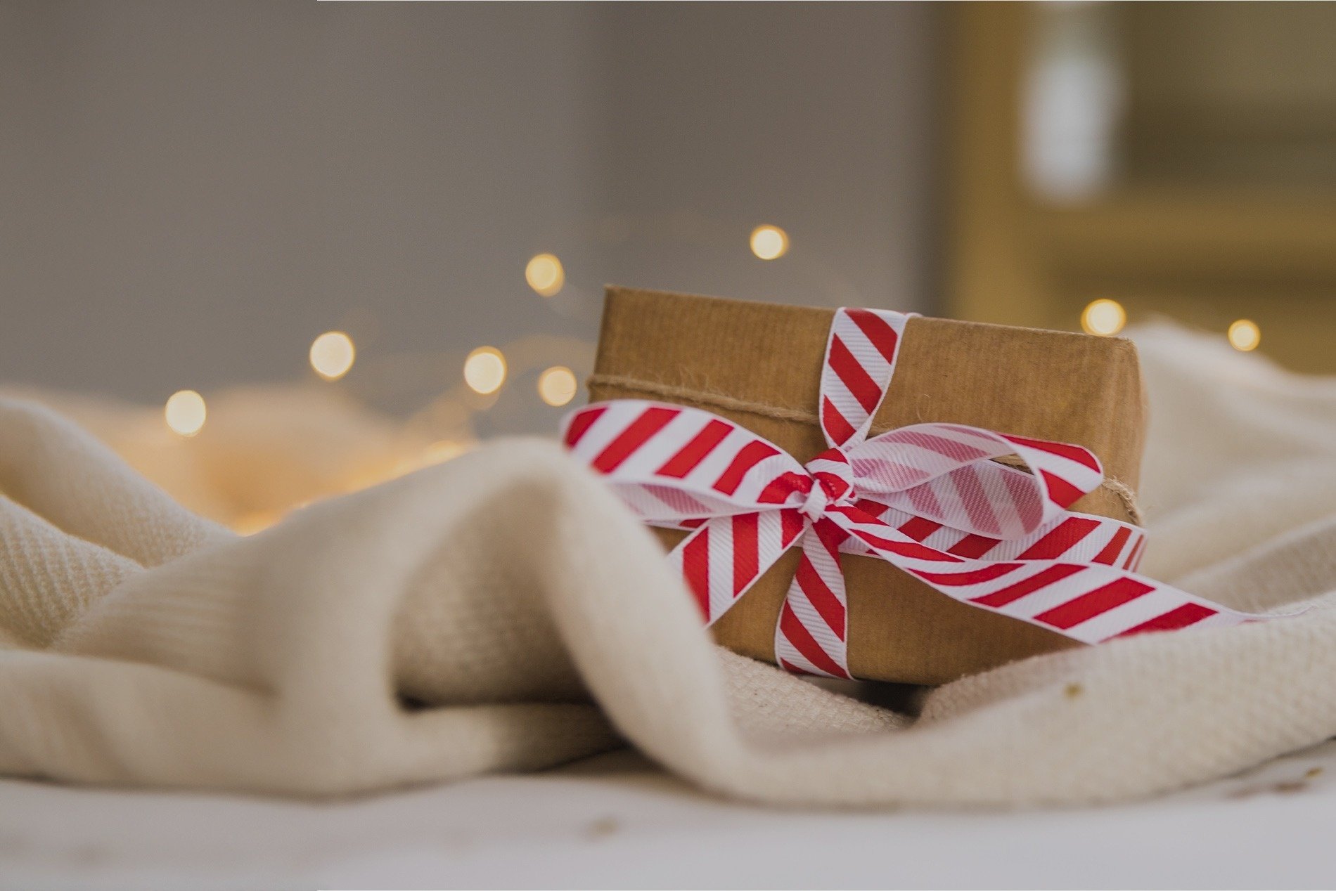 a brown box with a red and white striped ribbon tied around it