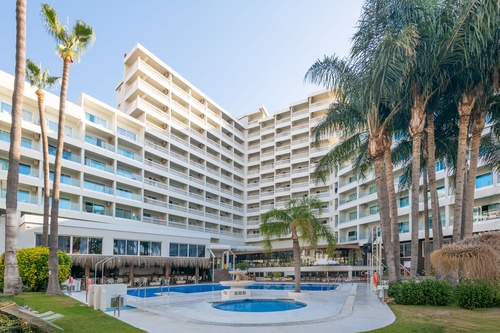 a large building with palm trees in front of it