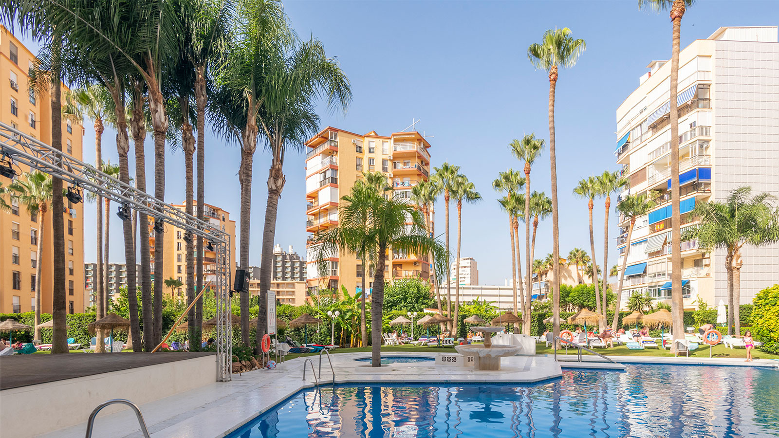 Resort pool with palm trees and apartment buildings. Dorobe