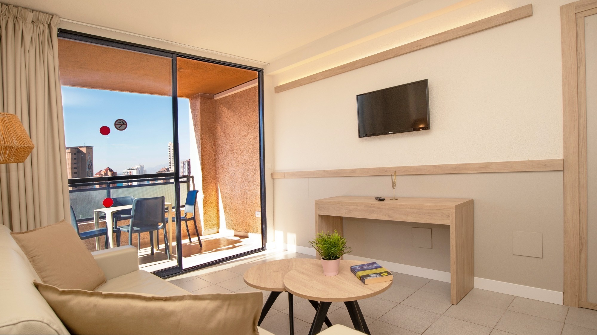 a living room with two tables and a flat screen tv