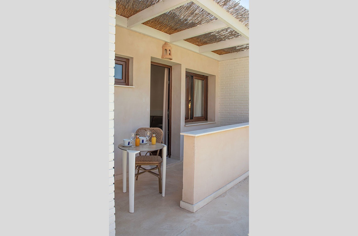 Terraza privada con mesa y sillas, ideal para disfrutar del desayuno, Dynastic Corporativa.