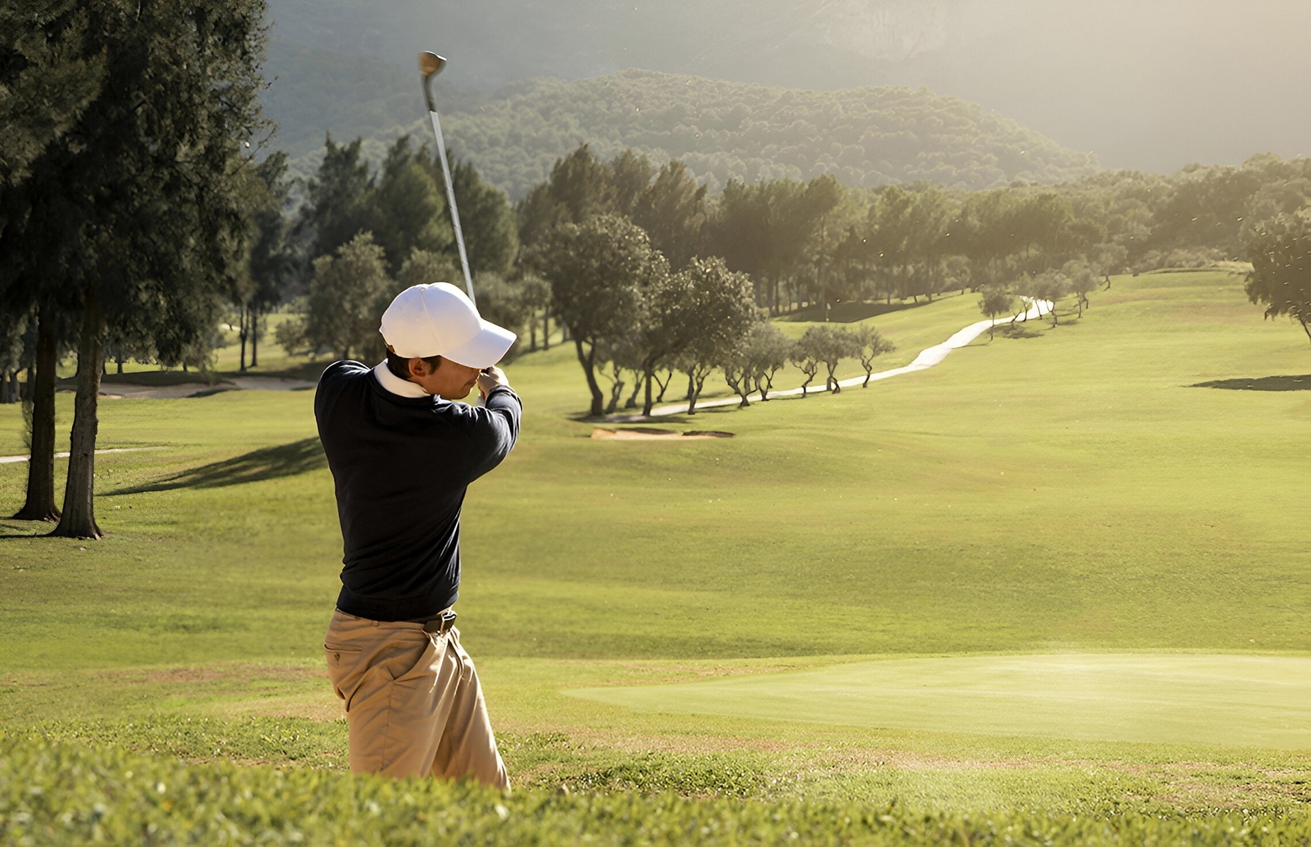 um homem está jogando golfe em um campo de golfe