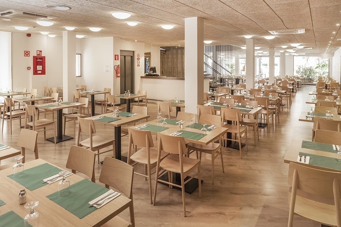 a restaurant with many tables and chairs and a fire extinguisher on the wall