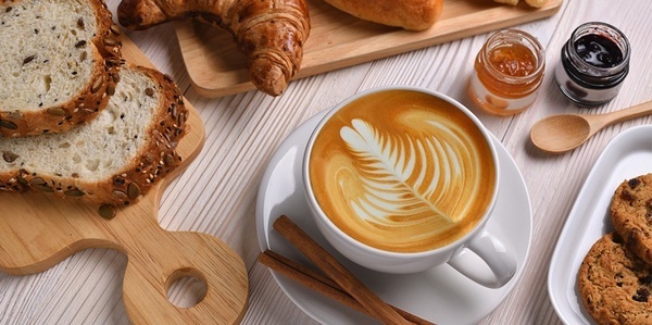 uma xícara de café com uma folha desenhada na espuma