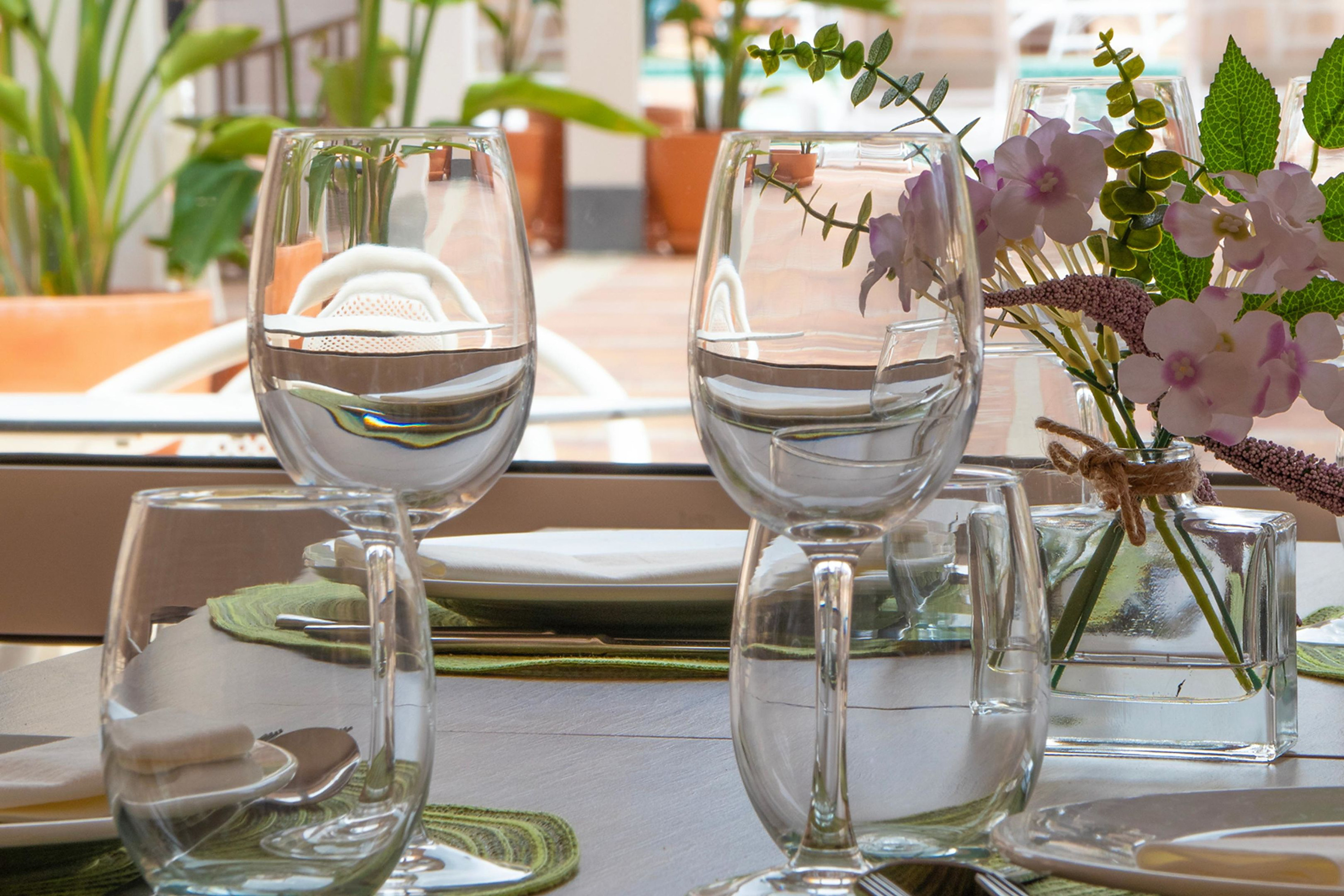 Copas de vino con flores y plantas en un entorno tropical para tu Dynastic Corporativa.