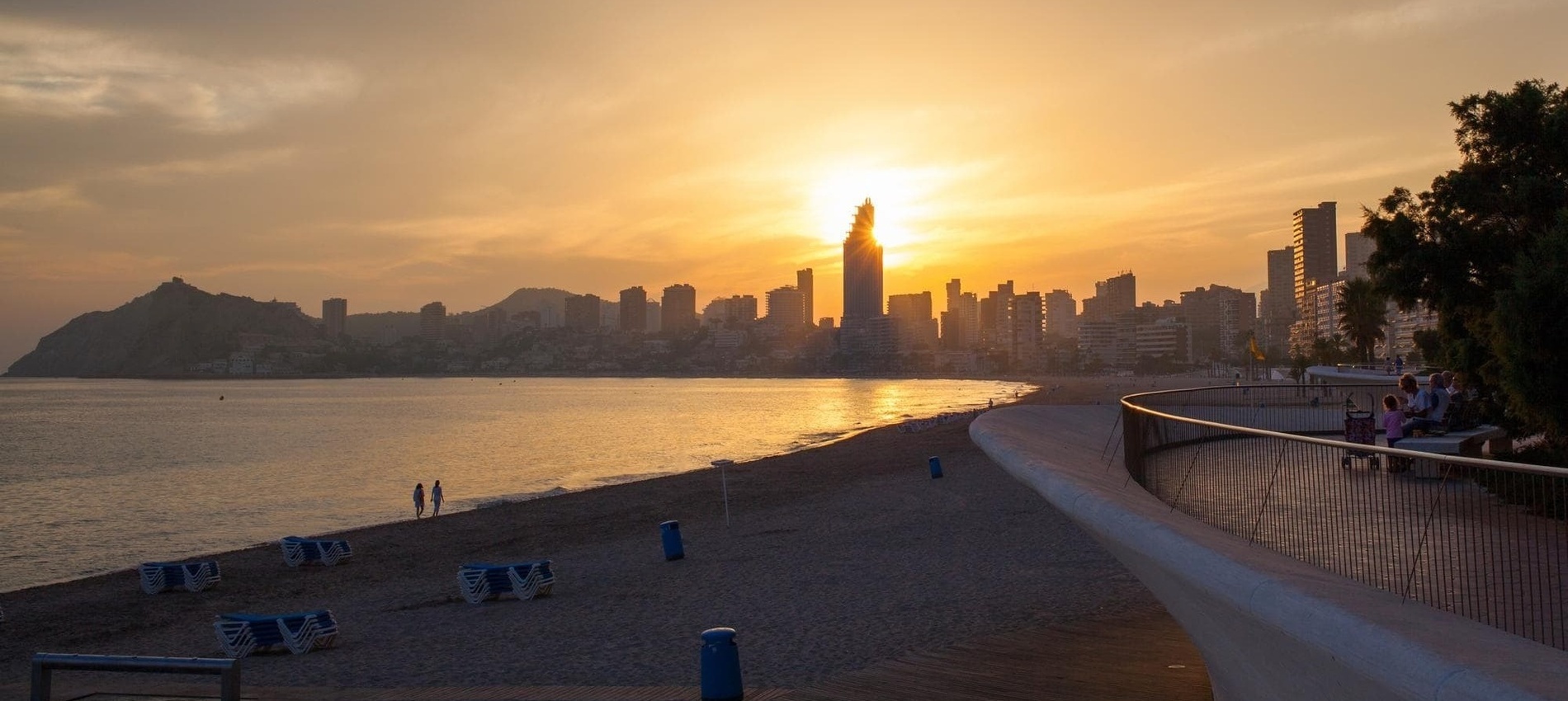 o sol está se pondo sobre o horizonte da cidade ao fundo