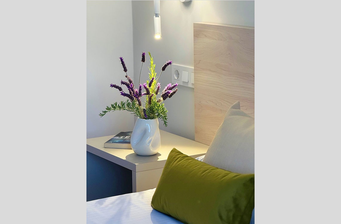 Arreglo floral y cojines en suite Dynastic Corporativa.