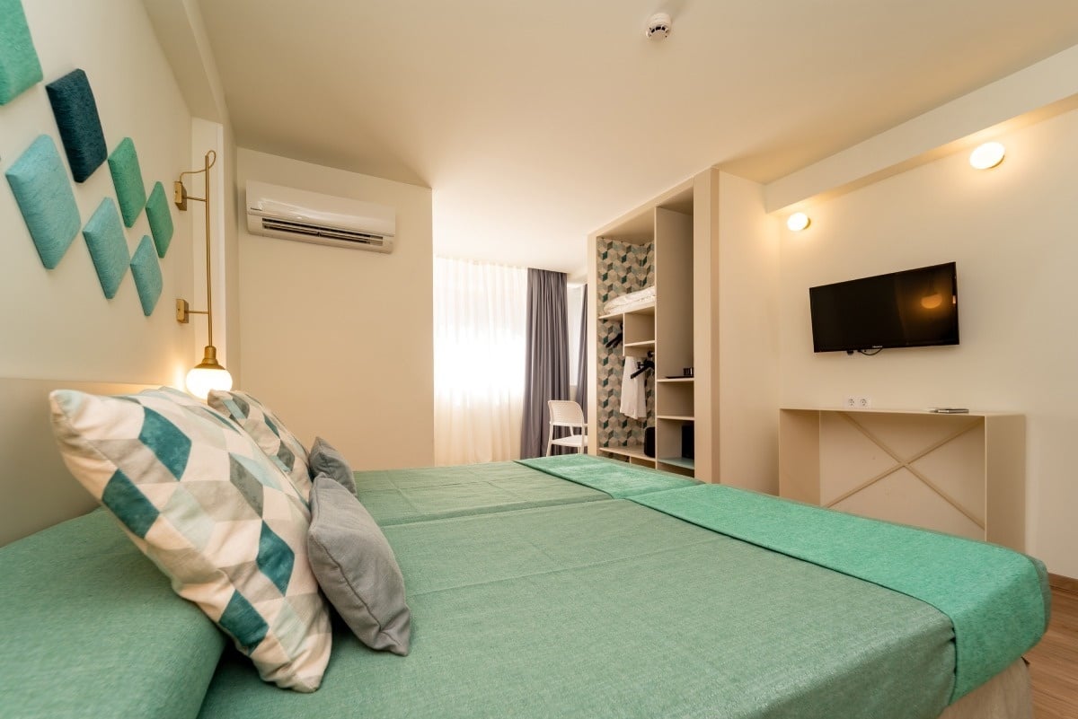 a bedroom with two beds and a flat screen tv