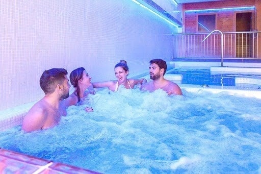 a group of people are sitting in a hot tub .