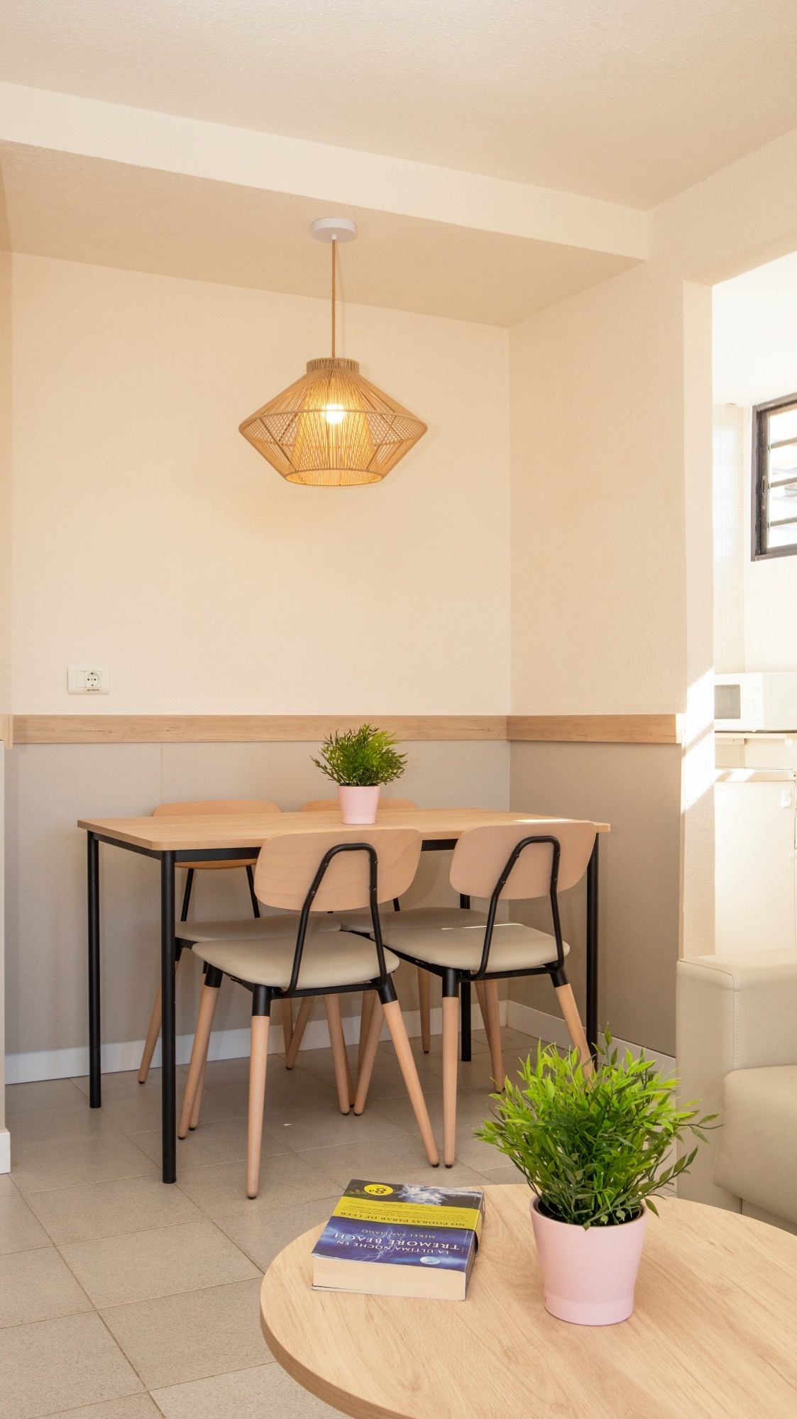 a dining room with a table and chairs and a potted plant