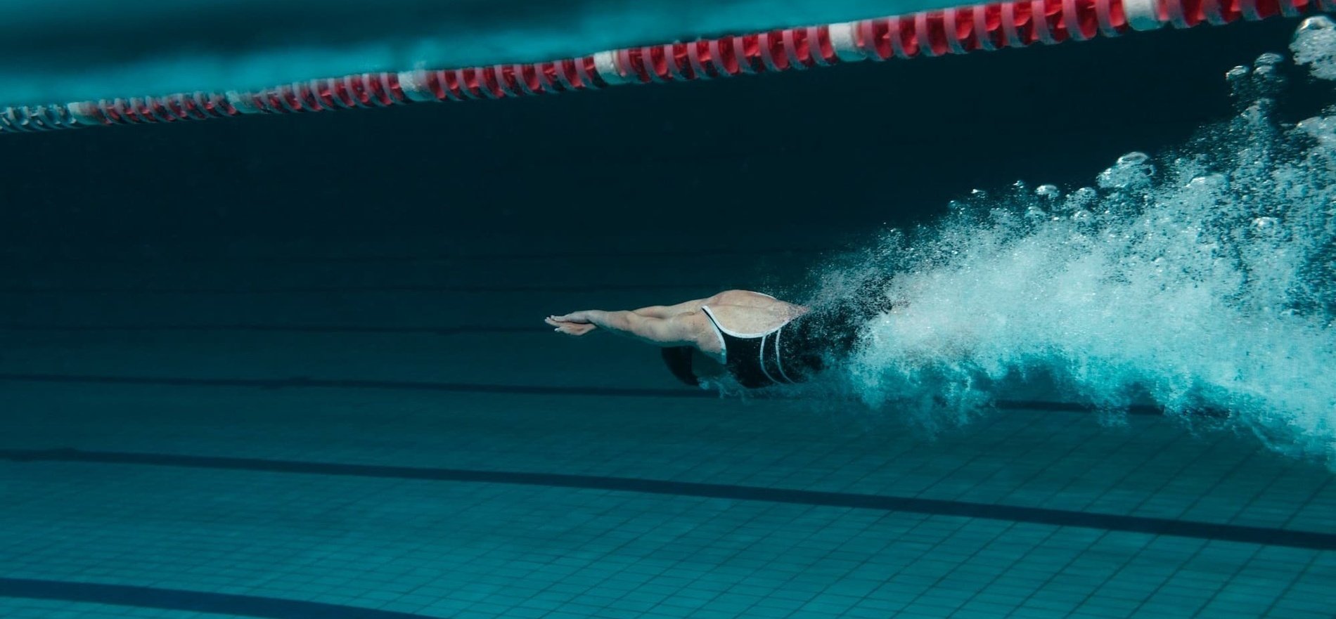 a person is swimming in a pool with a red white and blue border