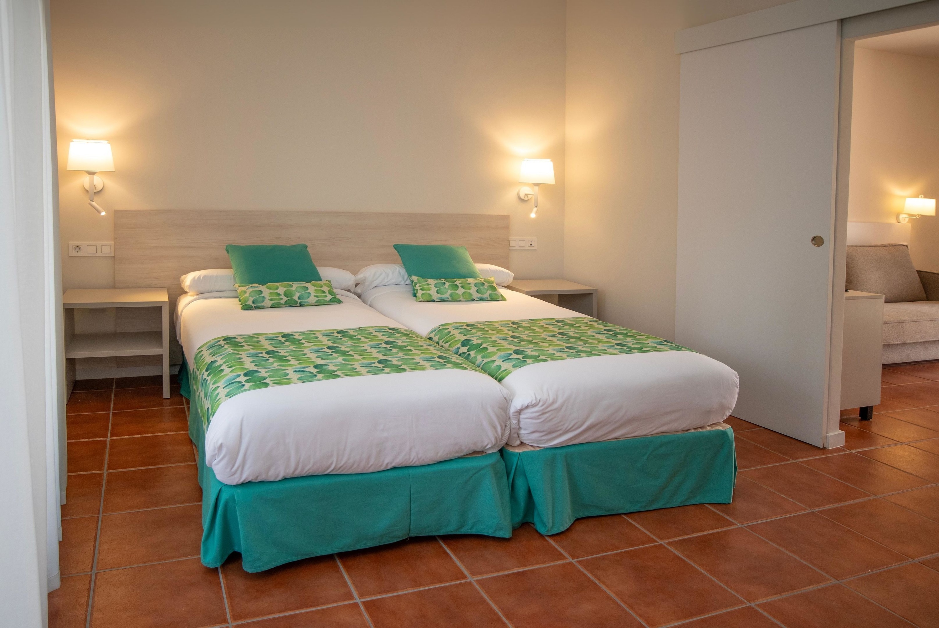 Habitación con dos camas individuales y decoración moderna en Dynastic Corporativa.