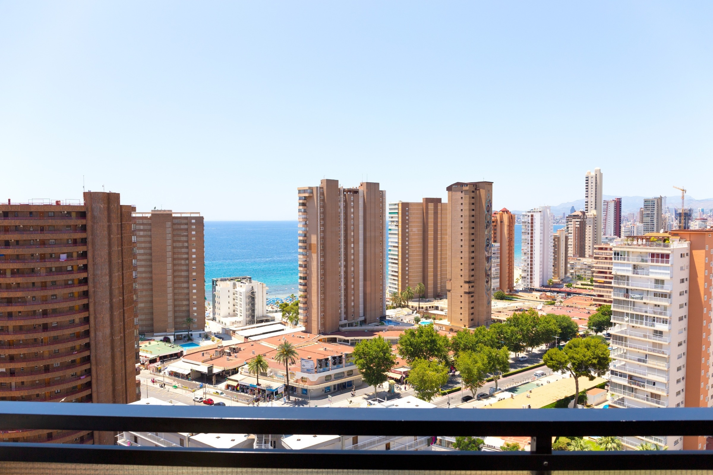 a view of a city with a lot of tall buildings and the ocean in the background