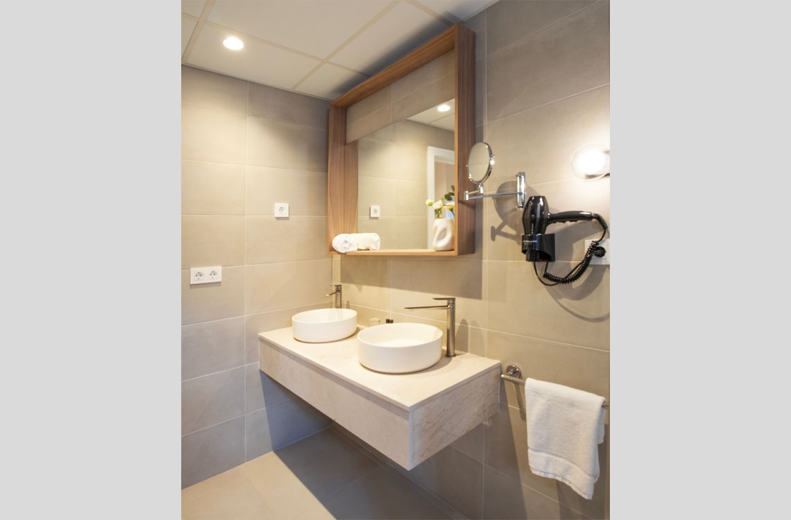 Modern baño Dynastic Corporativa con doble lavabo y secador de pelo.