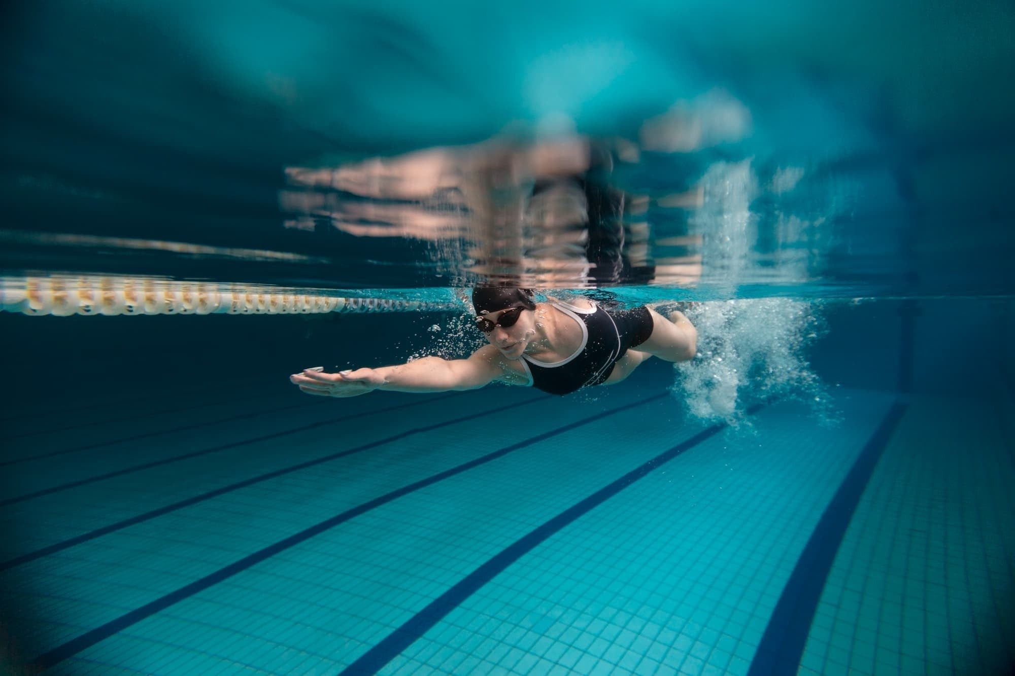 Swimmer in the hotel pool, underwater view.