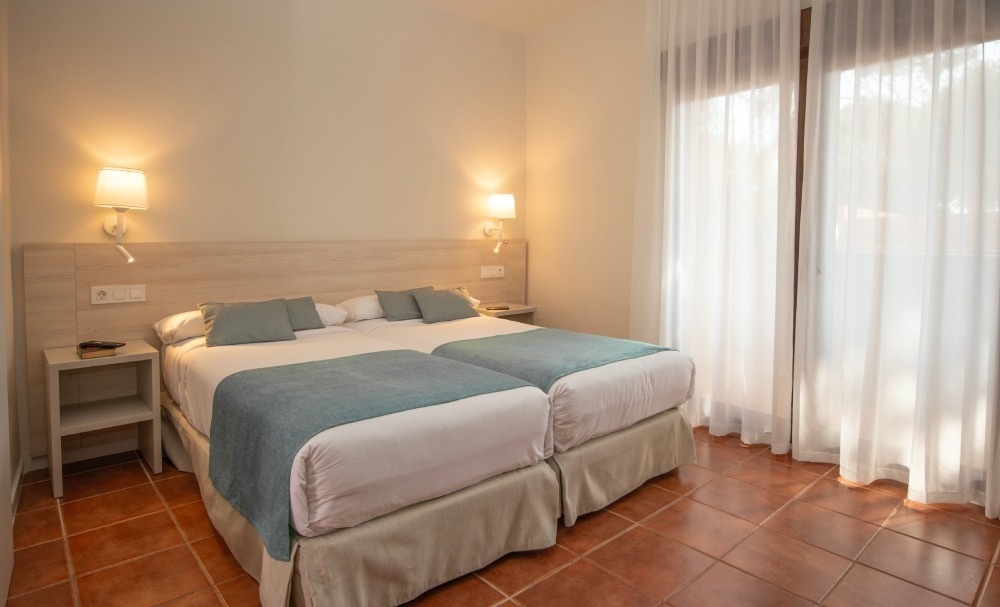 a hotel room with two beds and a window