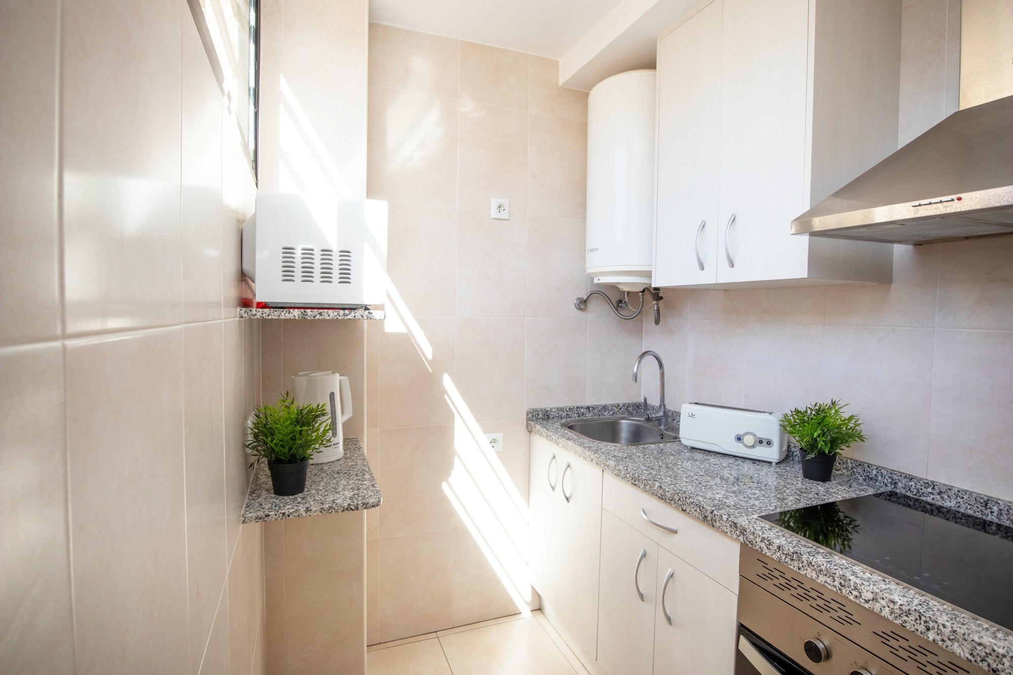 a kitchen with a stove top oven a sink and a microwave
