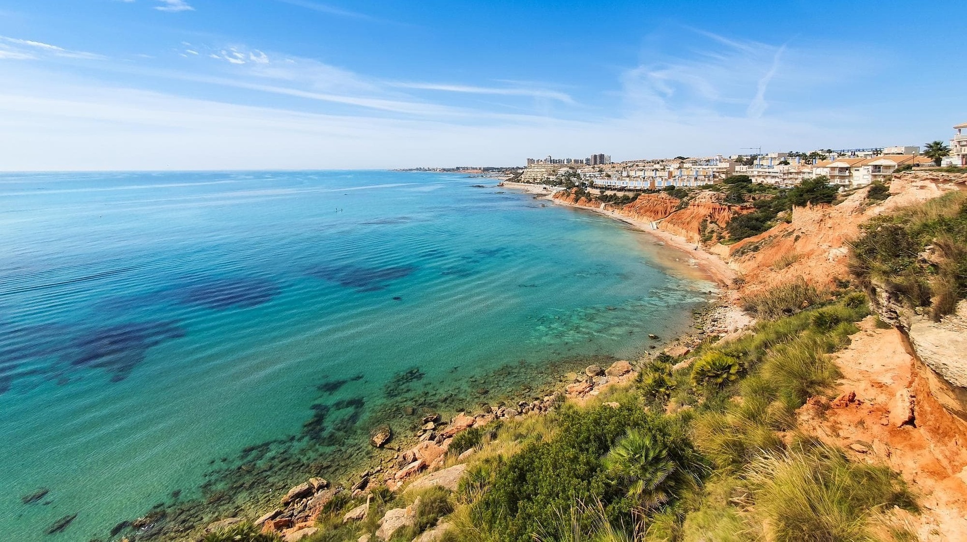 uma vista aérea de um oceano com uma cidade ao fundo