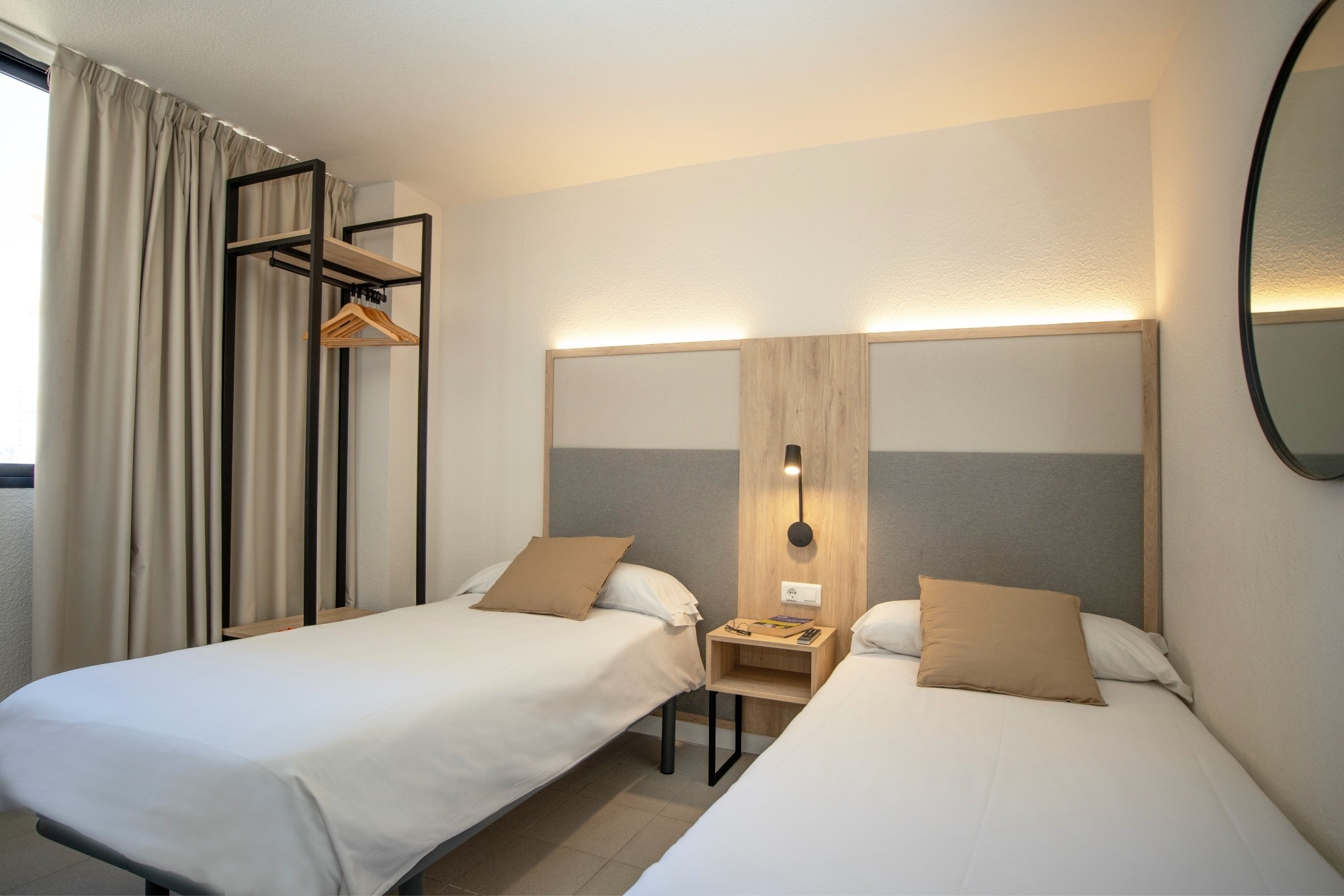 a hotel room with two beds and a mirror