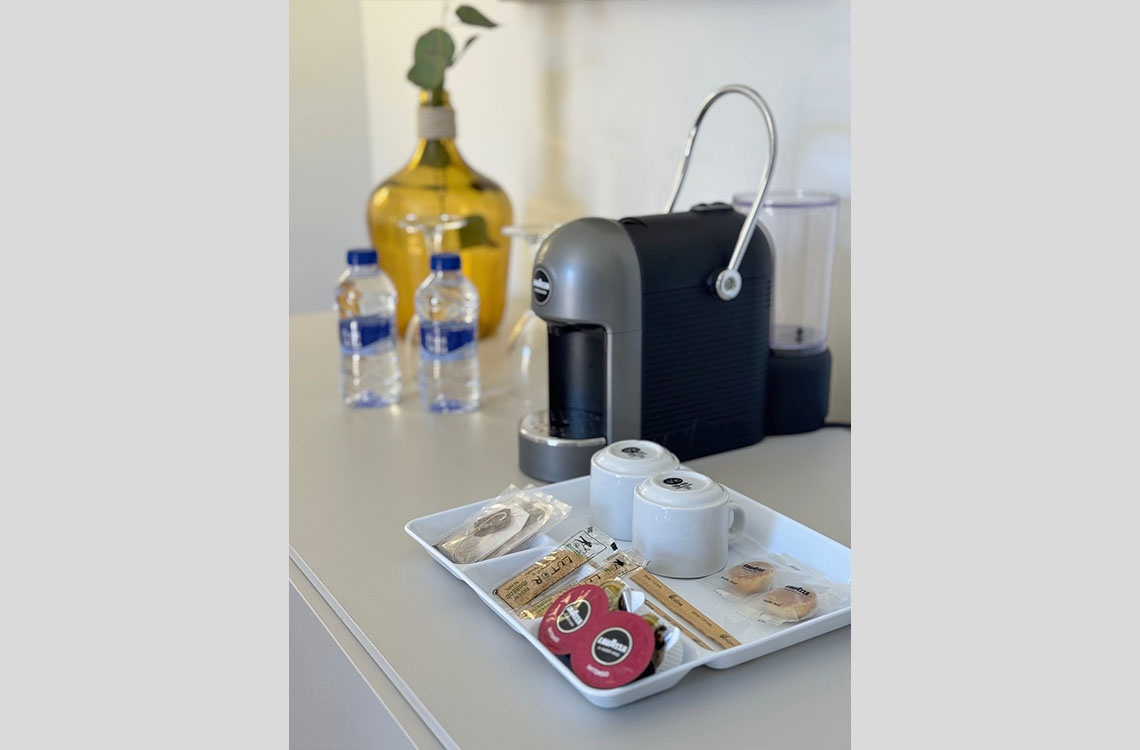 Cafetera Dynastic Corporativa con té, café y galletas en bandeja.