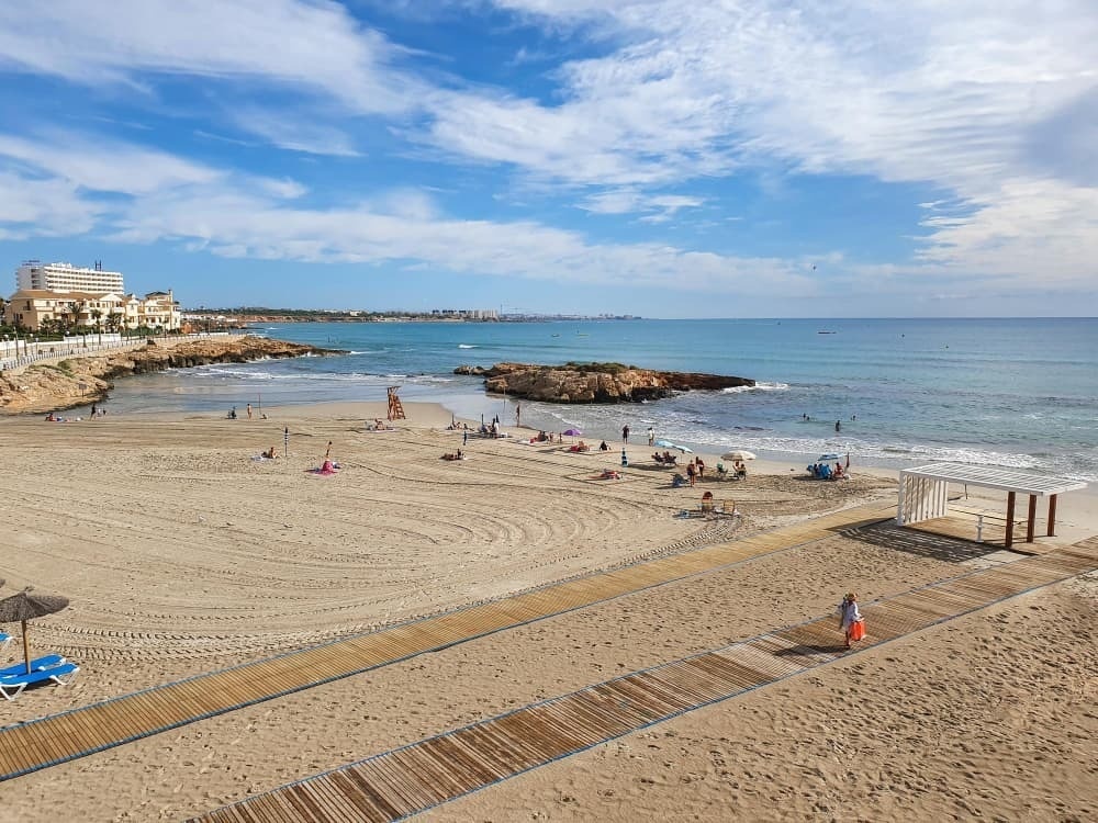 a beach scene with a hotel in the background