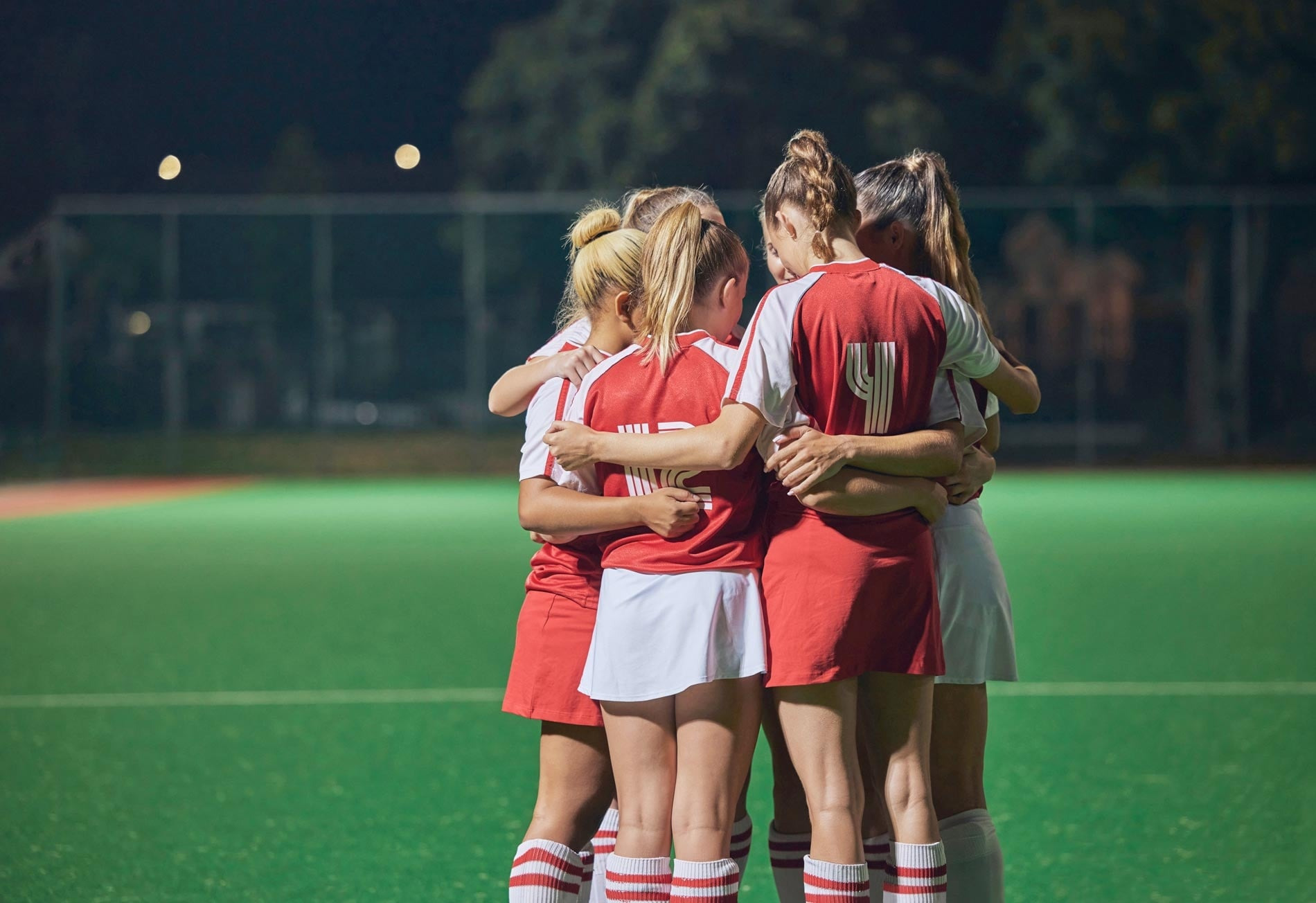 Jugadoras de hockey en círculo en el campo, Dynastic Resorts