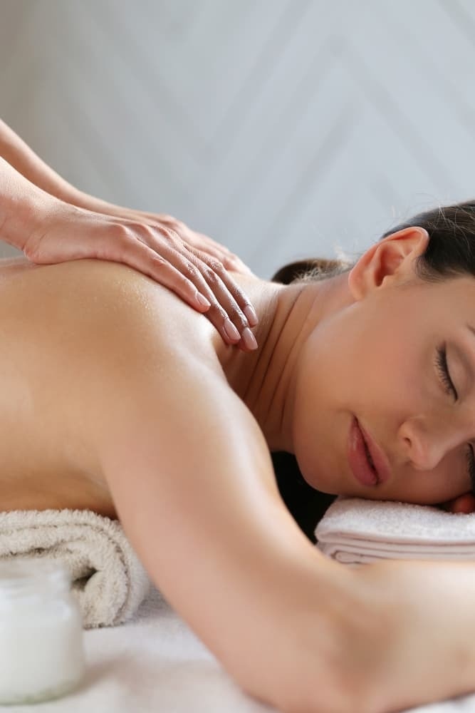 uma mulher está recebendo um massagem nas costas em um spa
