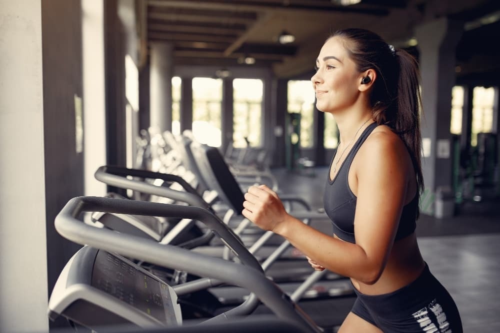 a woman is running on a treadmill in a gym