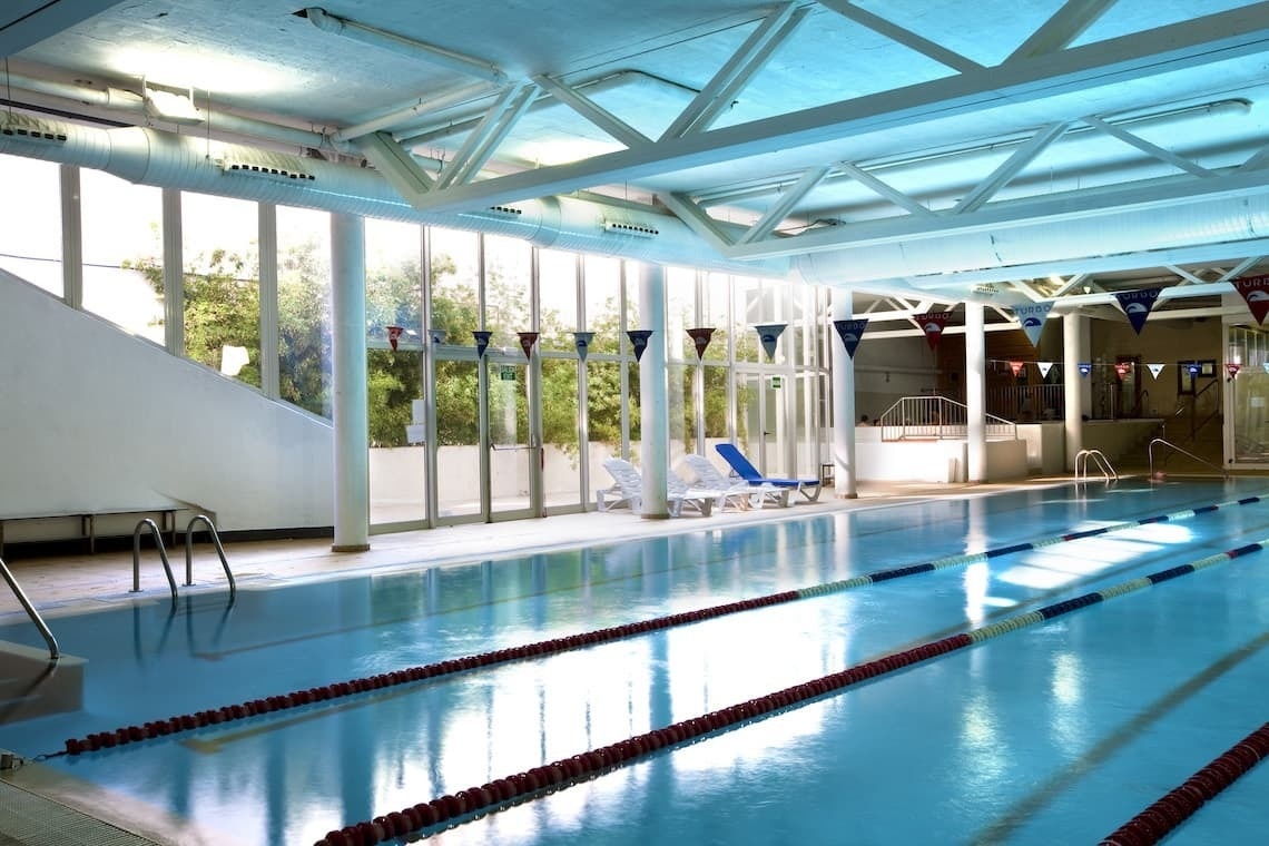 a large indoor swimming pool with flags hanging from the ceiling