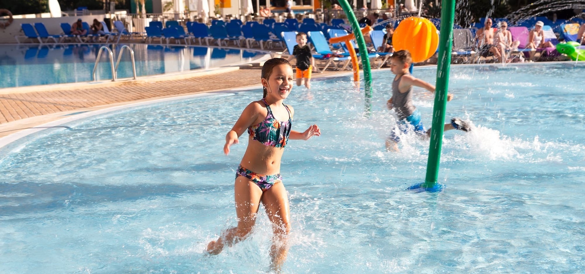 un niño y una niña juegan en una piscina