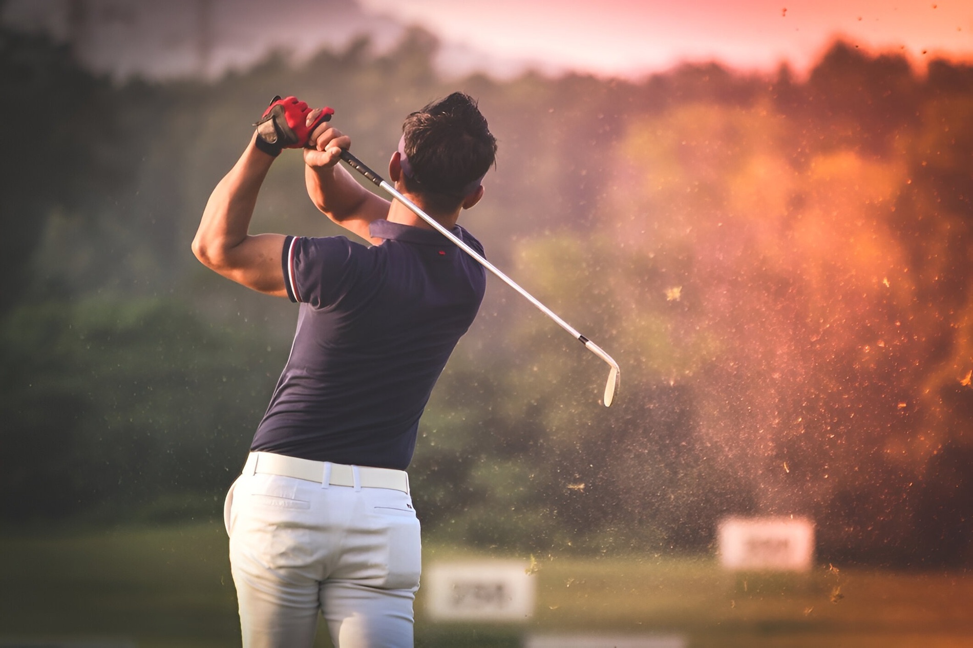 um homem está batendo uma bola de golfe em um campo de golfe
