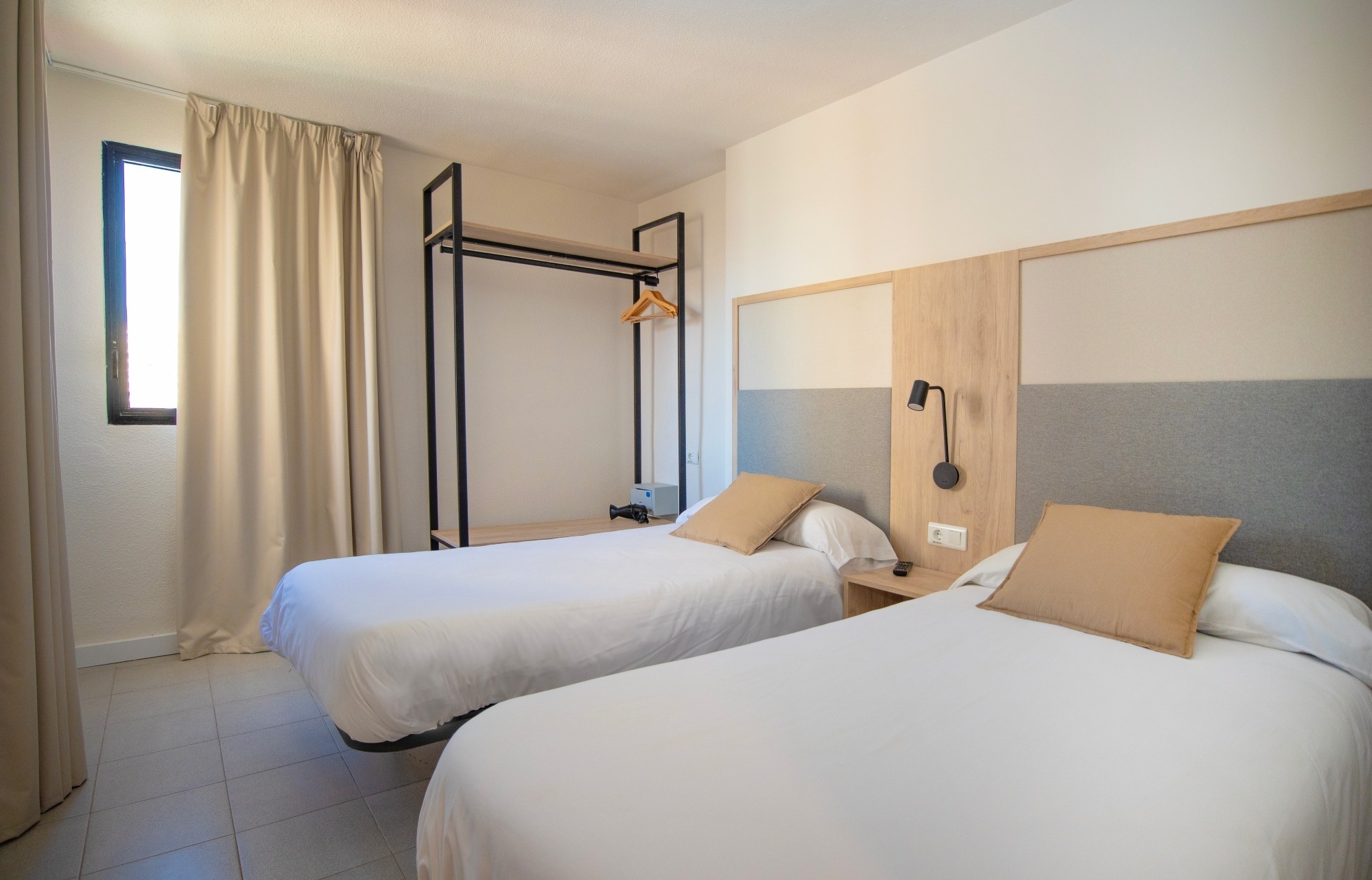 a hotel room with two beds and a window