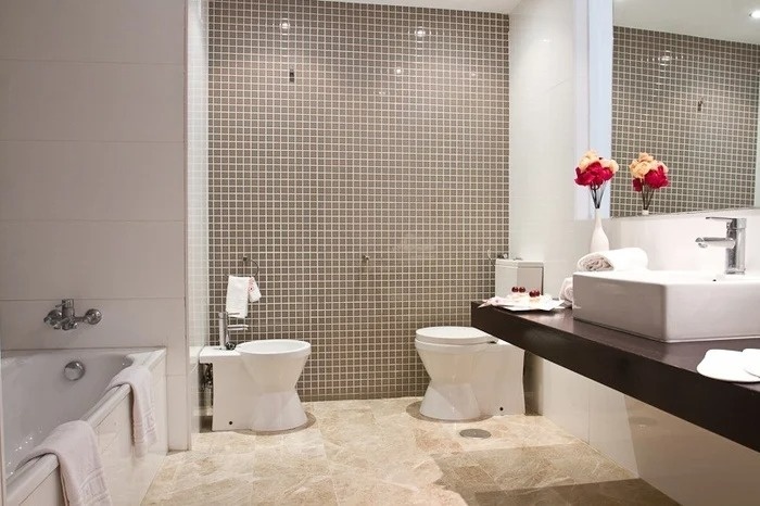 a bathroom with a sink toilet and bidet
