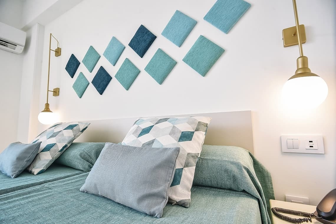 a hotel room with a bed and pillows on it