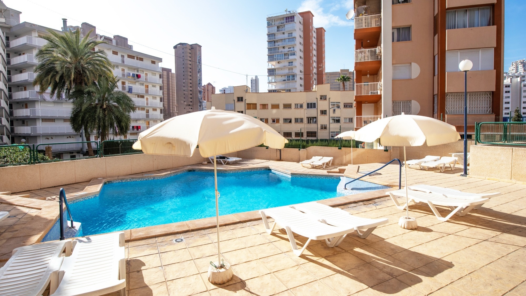 a large swimming pool surrounded by chairs and umbrellas
