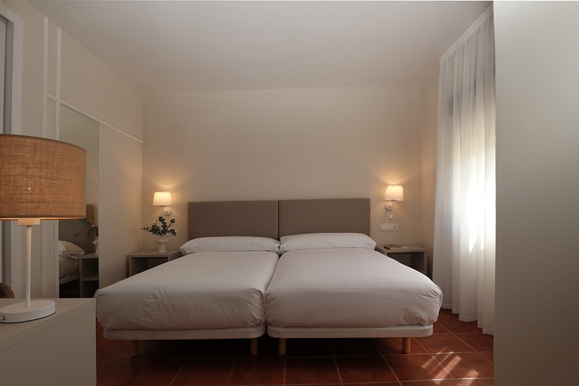 una habitación con dos camas y dos lámparas