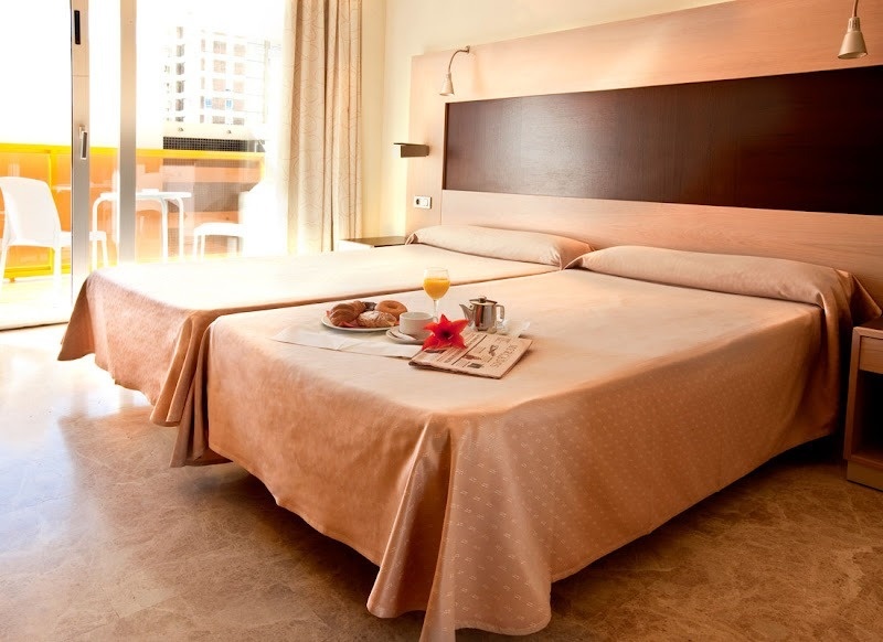 a hotel room with two beds and a newspaper on the bed
