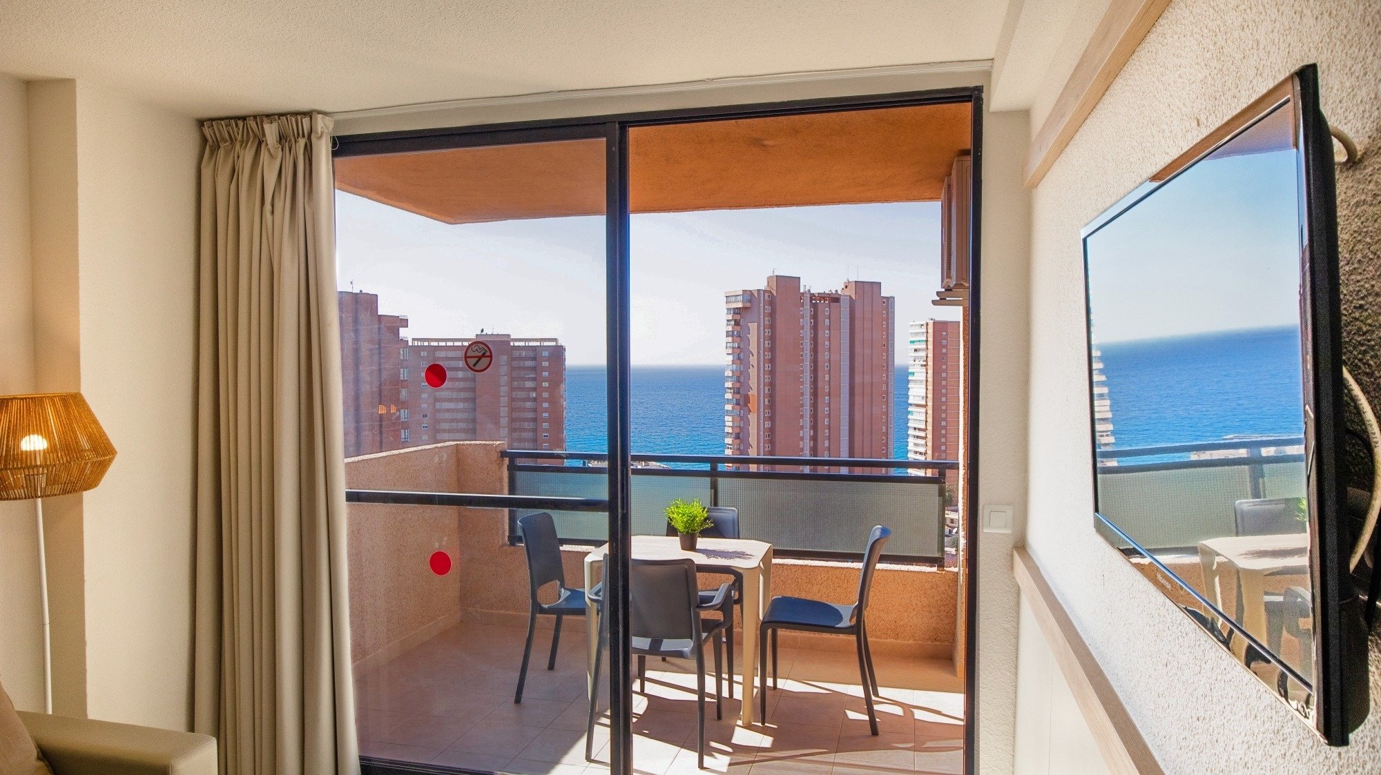 a sliding glass door leading to a balcony overlooking the ocean