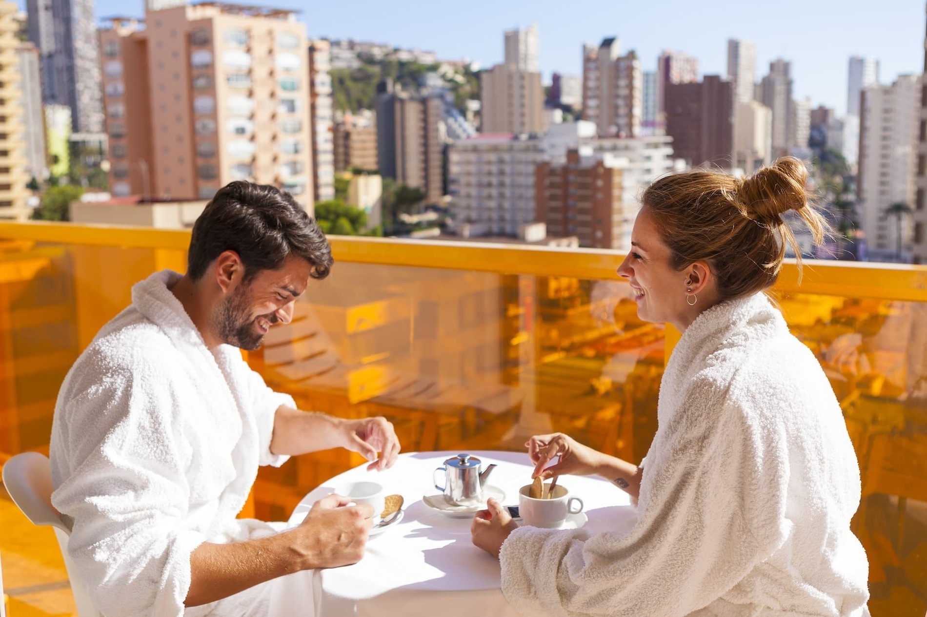 a man and a woman are sitting at a table drinking coffee