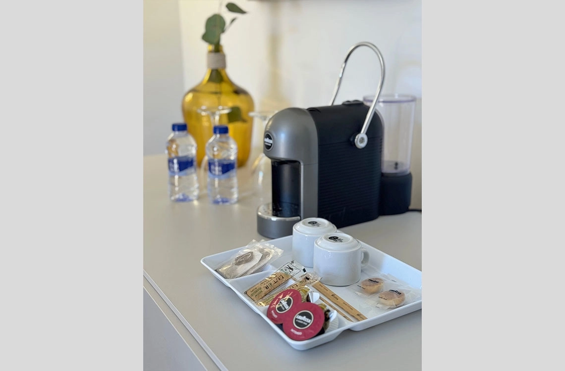 Dynastic Resorts: cafeteira e cortesias em hotel, com água e biscoitos.