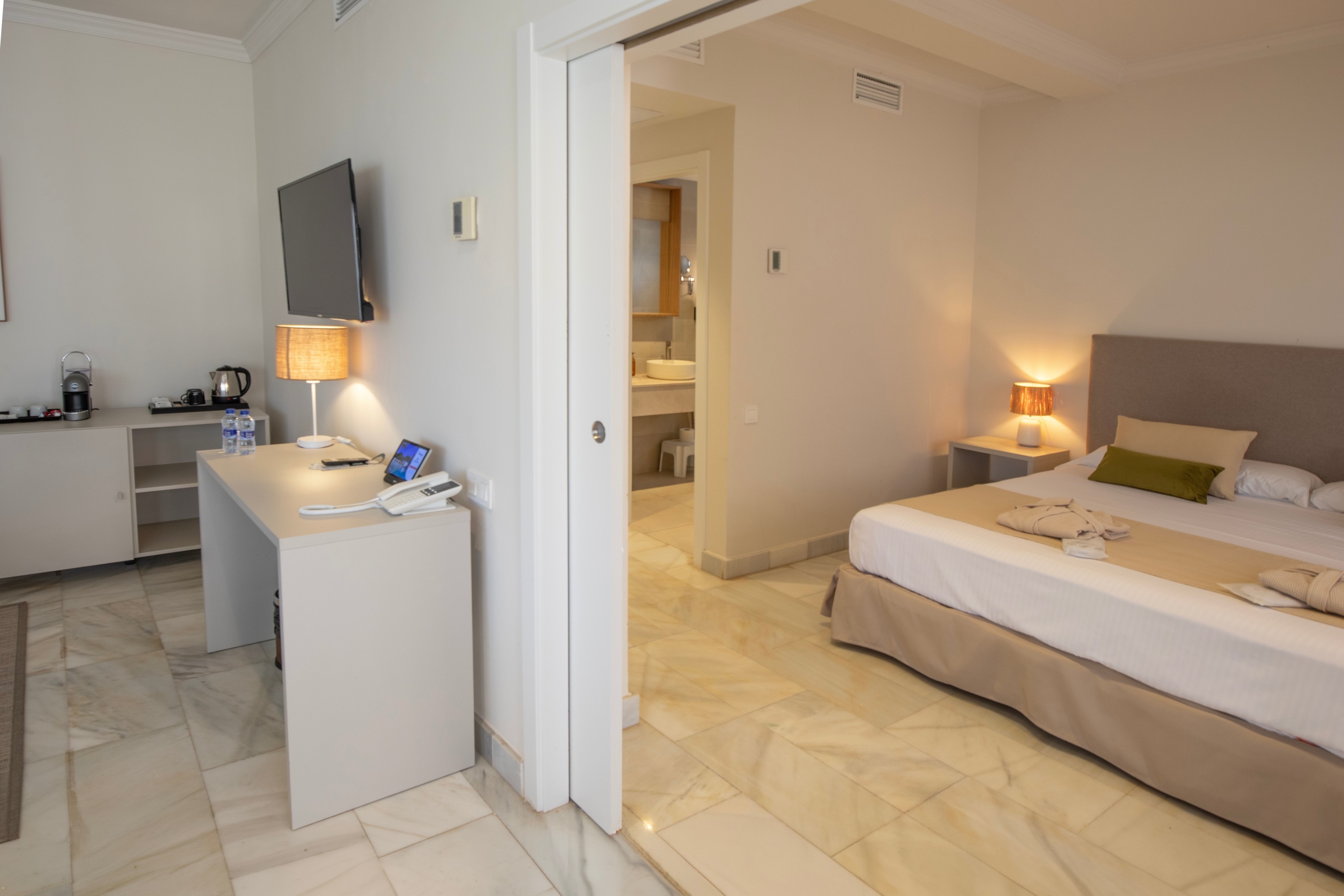 Habitación de hotel Dynastic: cama cómoda, escritorio y baño.