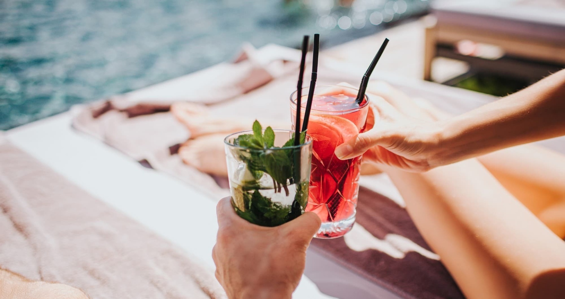 un hombre y una mujer sostienen dos bebidas con pajitas