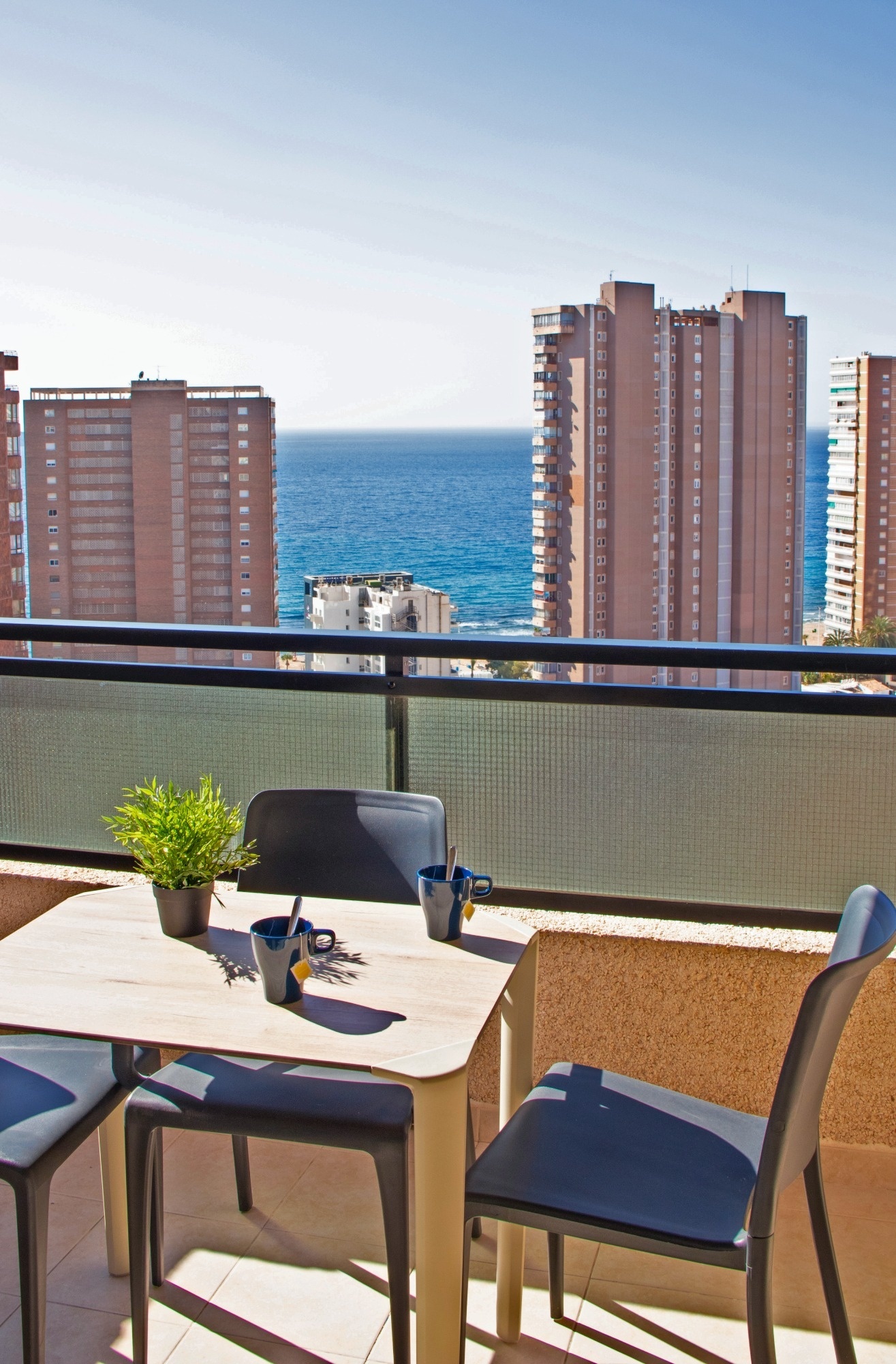 a table and chairs on a balcony overlooking the ocean