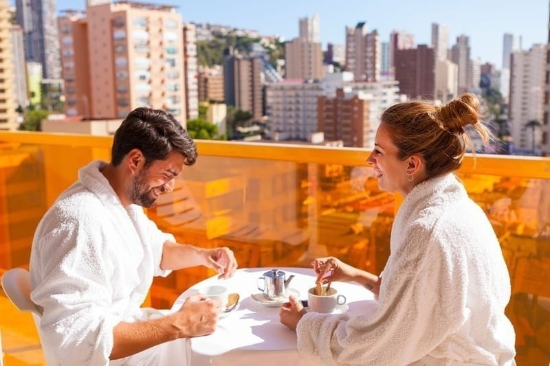 a man and a woman are sitting at a table drinking coffee