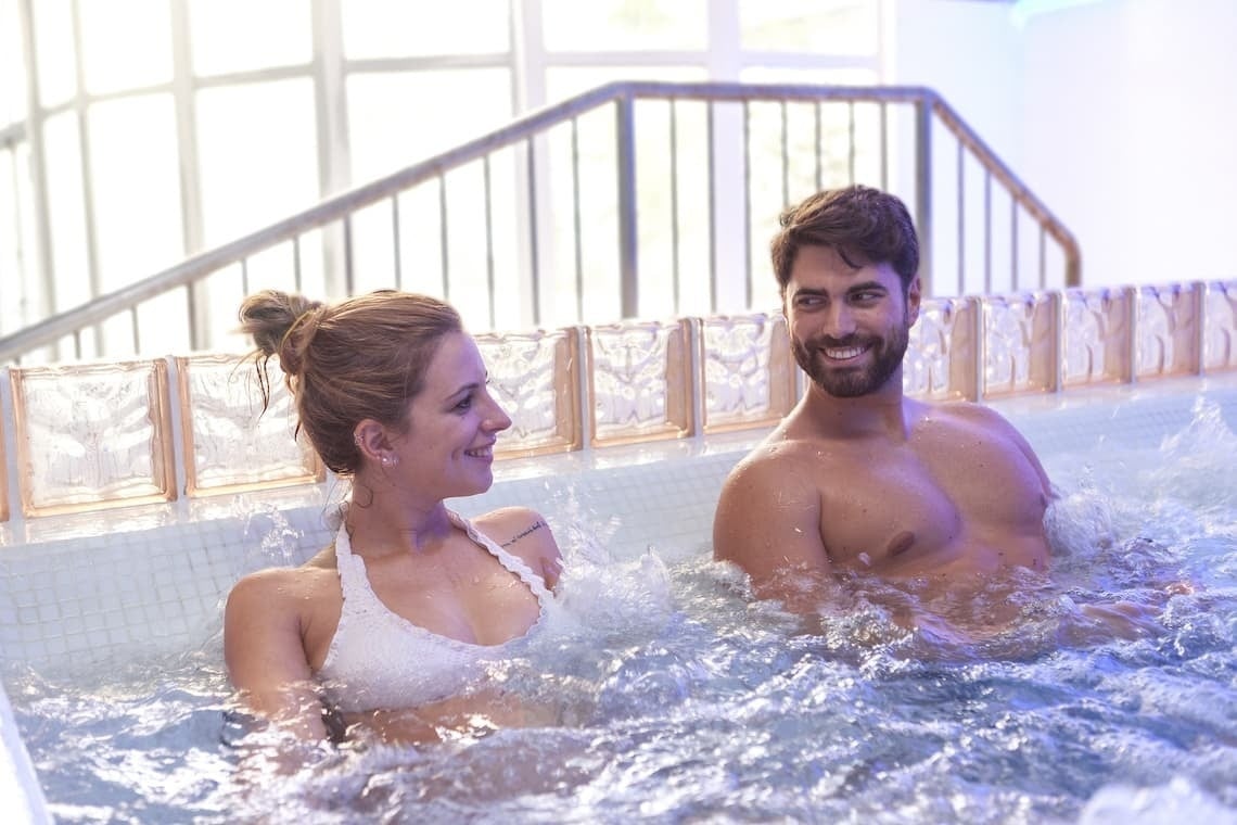 a man and a woman are sitting in a hot tub