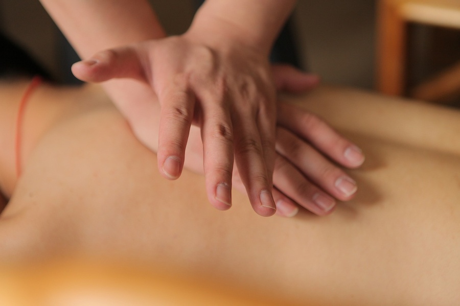 a person is getting a massage with their hands on their back